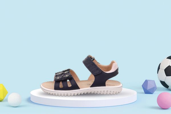 Blå Superfit Sparkle barnesandal i skinn med blomsterdetaljer og praktisk borrelåslukking.
