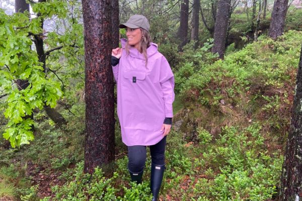 Blæst Bergen Poncho i violet med hette og frontlomme, designet for komfort og beskyttelse i regnvær.
