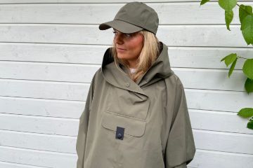 Blæst Bergen Poncho i fargen grape leaf med hette og frontlomme, ideell for regnværsdager, festivaler og turer.
